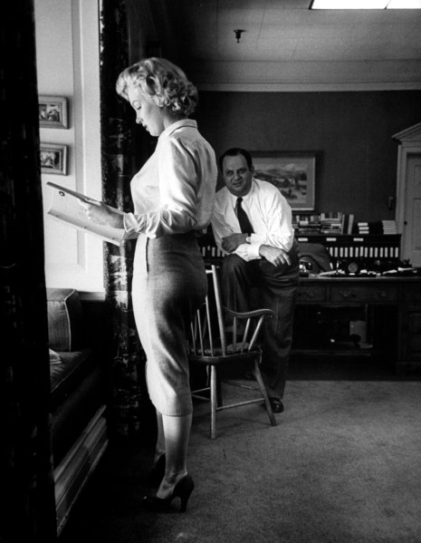 Bob Landry photographs Marilyn studying a script in producer Jerry Wald's office, 1951